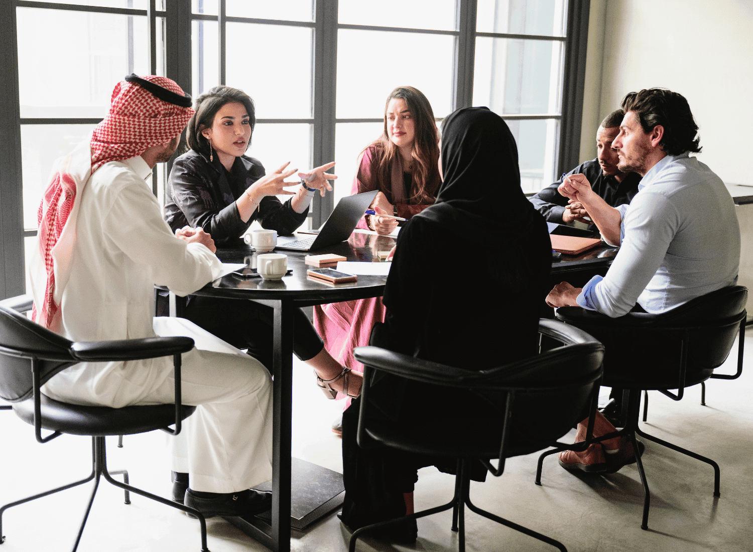 a team of saudi managers discussing skills training for a productive environment